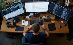 Developer with three monitors